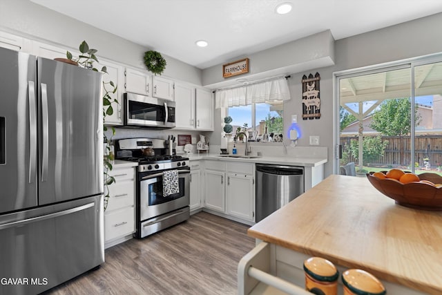 3616 Glenridge Ave, Rosamond, CA 93560 - kitchen with appliances with stainless steel finishes, light countertops, white cabinetry, recessed lighting, and wood finished floors
