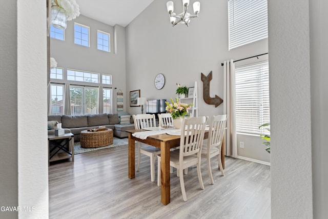 3616 Glenridge Ave, Rosamond, CA 93560 - dining space featuring a chandelier, a high ceiling, and light wood-style flooring