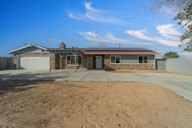 ranch-style home featuring solar panels and a garage