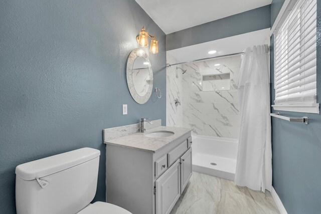 bathroom featuring vanity, toilet, and curtained shower