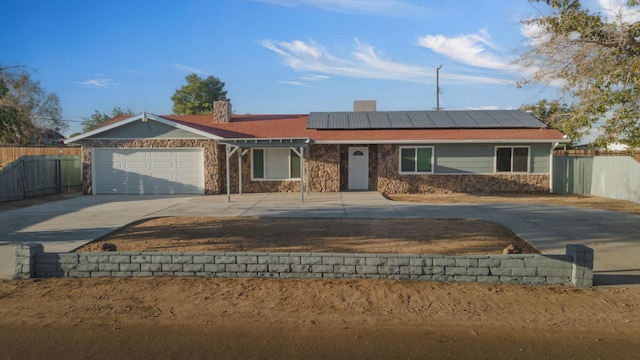 single story home with solar panels and a garage