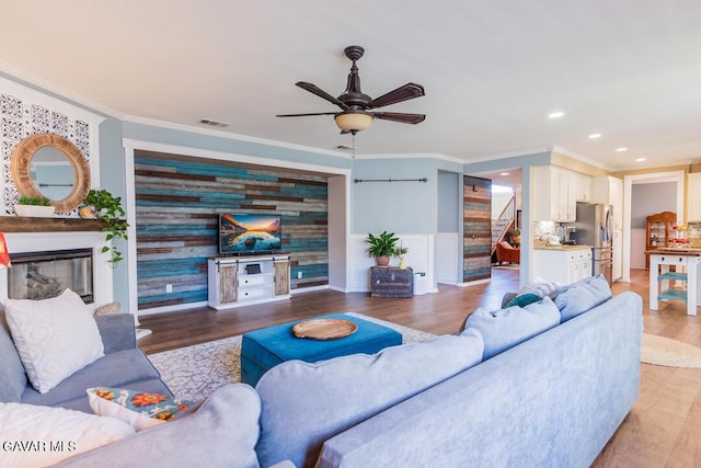 3455 Pine Mist Ct, Rosamond, CA 93560 - living area with crown molding, light wood-type flooring, ceiling fan, recessed lighting, and stairway