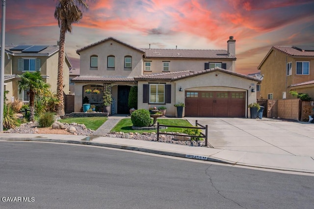 3455 Pine Mist Ct, Rosamond, CA 93560 - mediterranean / spanish-style house with stucco siding, an attached garage, driveway, a tile roof, and a chimney