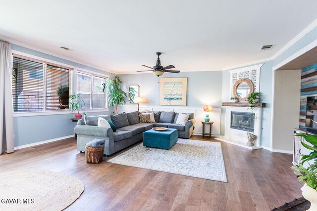 3455 Pine Mist Ct, Rosamond, CA 93560 - living room with ornamental molding, wood finished floors, ceiling fan, and a glass covered fireplace