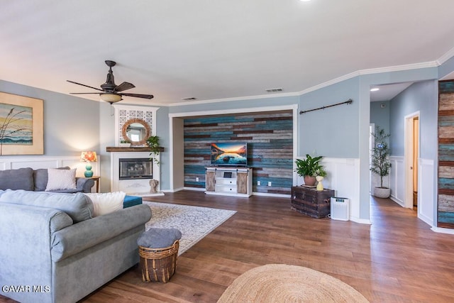 3455 Pine Mist Ct, Rosamond, CA 93560 - living area featuring ceiling fan, a glass covered fireplace, wainscoting, wood finished floors, and ornamental molding