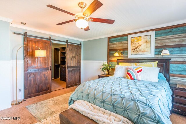 3455 Pine Mist Ct, Rosamond, CA 93560 - carpeted bedroom featuring a barn door, wainscoting, crown molding, and a ceiling fan