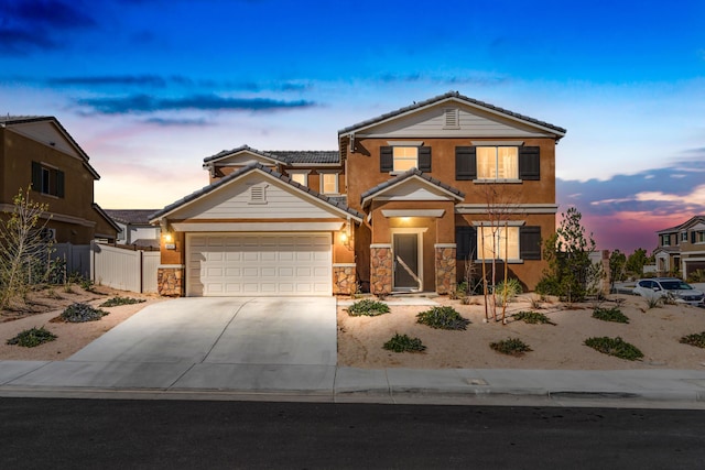 traditional-style house with an attached garage, fence, concrete driveway, stone siding, and a tiled roof