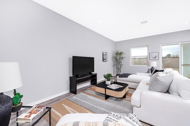 living room featuring hardwood / wood-style floors and vaulted ceiling