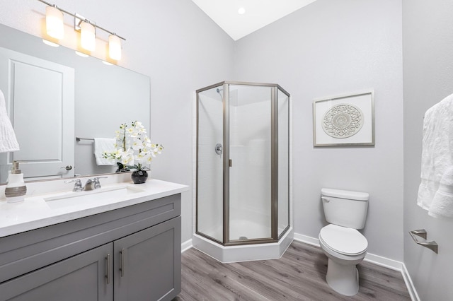 bathroom featuring hardwood / wood-style floors, vanity, toilet, and walk in shower