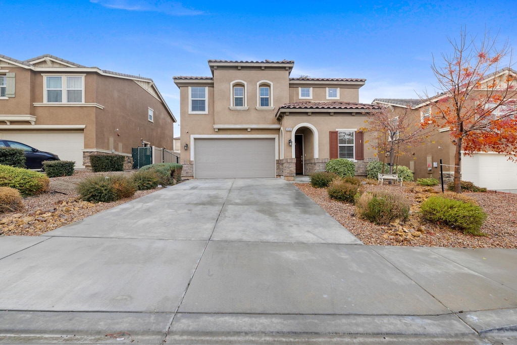 mediterranean / spanish house featuring a garage and central AC