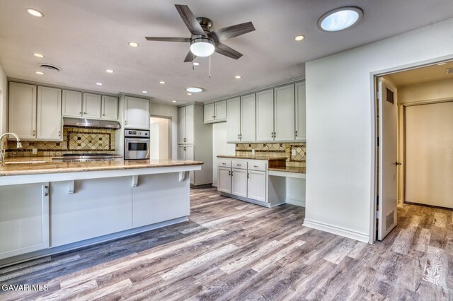 43737 W 27th St, Lancaster, CA 93536 - kitchen with stainless steel appliances, under cabinet range hood, backsplash, recessed lighting, and light stone countertops
