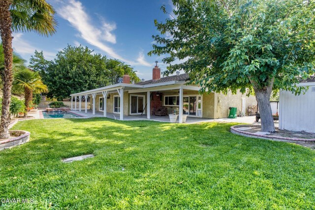 43737 W 27th St, Lancaster, CA 93536 - back of property featuring a chimney, a lawn, a patio, ceiling fan, and stucco siding