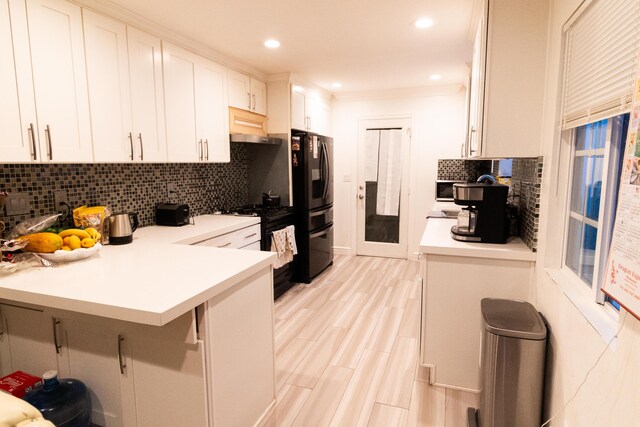 kitchen with a kitchen bar, decorative backsplash, kitchen peninsula, black appliances, and white cabinetry