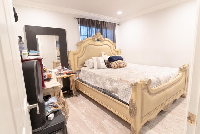 bedroom with crown molding and light hardwood / wood-style floors