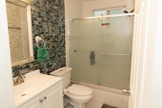 bathroom with backsplash, vanity, tile walls, and toilet