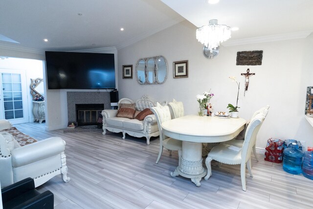 dining area featuring wood-type flooring, ornamental molding, and an inviting chandelier