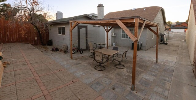 back house at dusk featuring a patio area