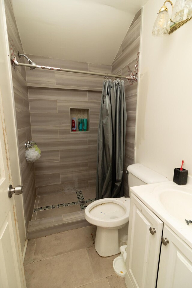 bathroom with a shower with shower curtain, vanity, vaulted ceiling, and toilet