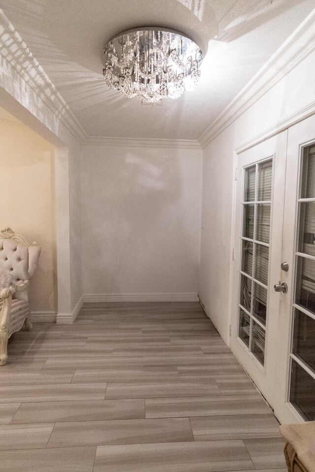 spacious closet with french doors, an inviting chandelier, and wood-type flooring