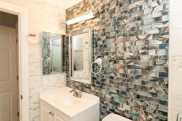 bathroom with decorative backsplash, vanity, and tile walls