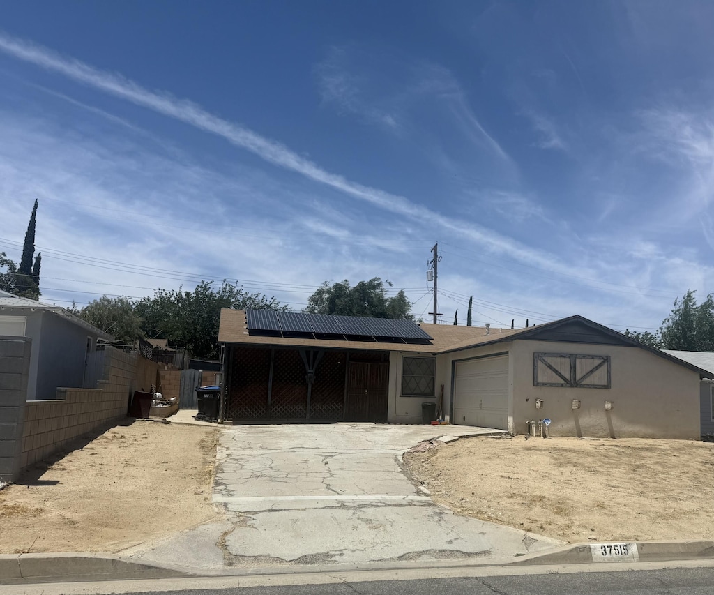 37515 Larkin Ave, Palmdale, CA 93550 - view of front of home with concrete driveway, a garage, and roof mounted solar panels