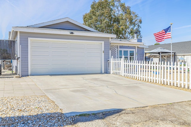 view of front facade featuring a detached garage and fence