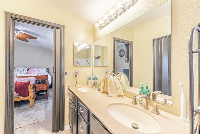 full bathroom with connected bathroom, a textured ceiling, and a sink