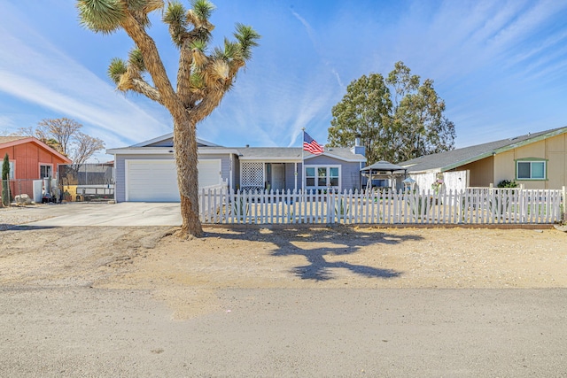 ranch-style house featuring a fenced front yard, a garage, and concrete driveway