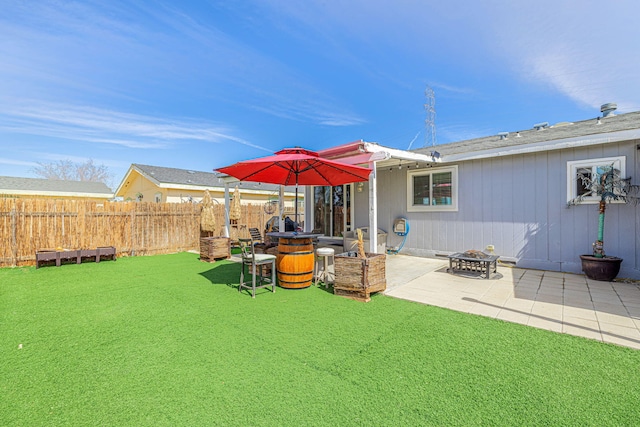 view of yard with a patio, fence, and an outdoor fire pit