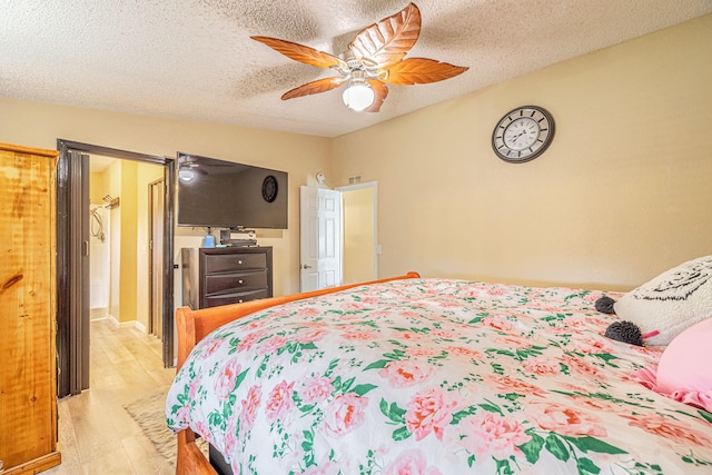 bedroom with light wood-style flooring, a textured ceiling, and ceiling fan