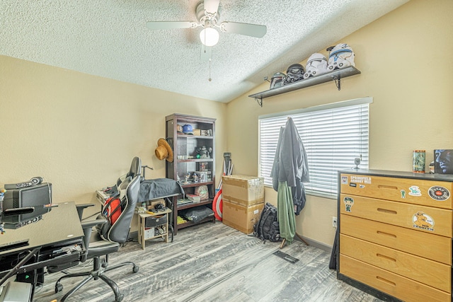 office space featuring wood finished floors, baseboards, lofted ceiling, ceiling fan, and a textured ceiling