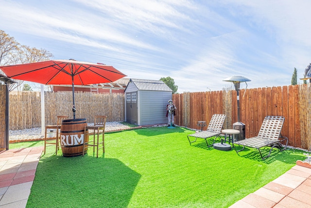 view of yard with an outbuilding, a fenced backyard, and a shed