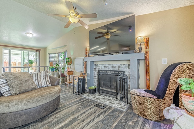 living room with lofted ceiling, a textured ceiling, wood finished floors, and a fireplace