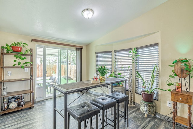 dining area with wood finished floors and vaulted ceiling