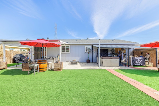 rear view of property featuring a patio area, fence, a hot tub, and a lawn