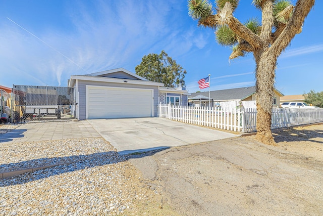 view of front of home with a fenced front yard, a garage, and driveway