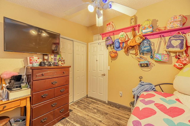 bedroom with a ceiling fan, a textured ceiling, a closet, light wood finished floors, and baseboards