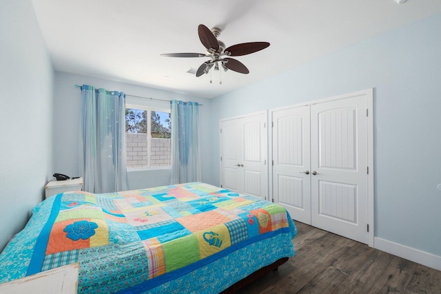 bedroom with multiple closets, wood finished floors, baseboards, and a ceiling fan