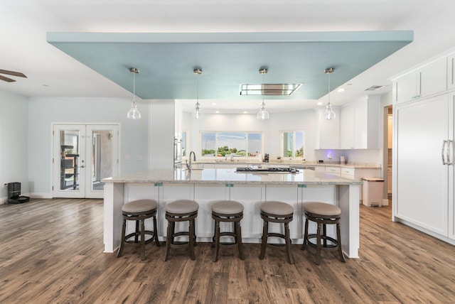 kitchen featuring dark wood-style flooring, white cabinetry, a breakfast bar area, and recessed lighting
