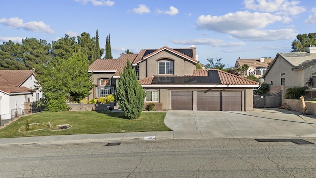 42164 Valley Vista Dr, Lancaster, CA 93536 - view of front of property featuring an attached garage, driveway, roof mounted solar panels, stucco siding, and a tiled roof