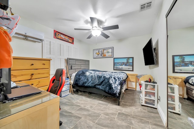 bedroom with a wall mounted AC, visible vents, and a ceiling fan