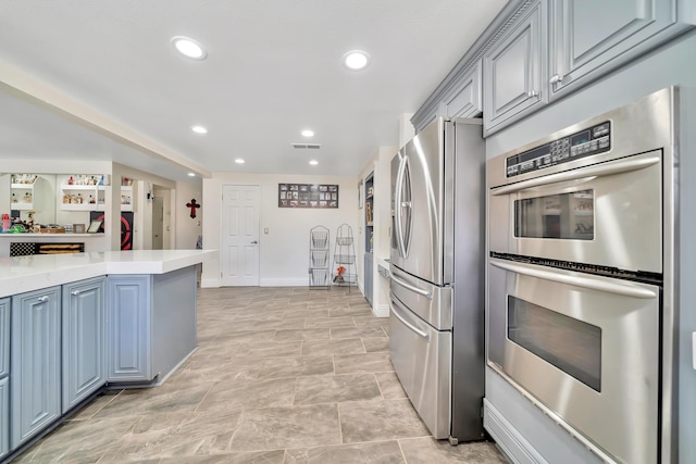 kitchen with visible vents, baseboards, stainless steel appliances, light countertops, and recessed lighting