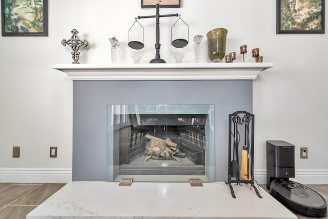 details featuring a fireplace with flush hearth and baseboards