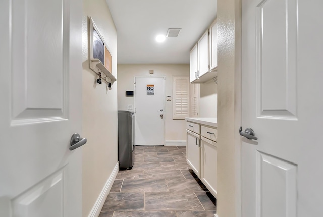 clothes washing area with visible vents and baseboards