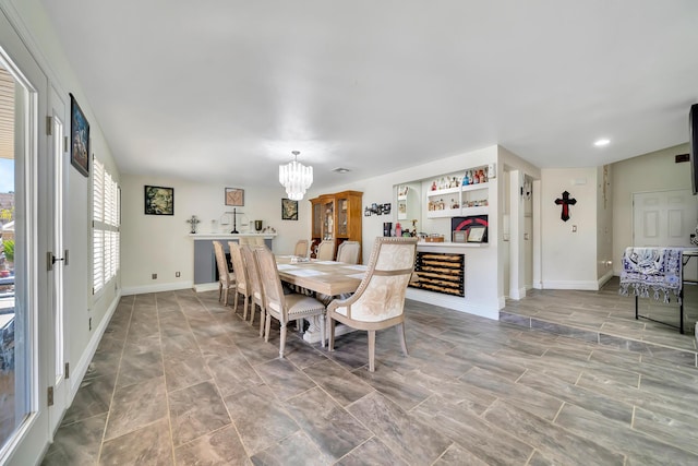 dining space featuring a chandelier, recessed lighting, and baseboards