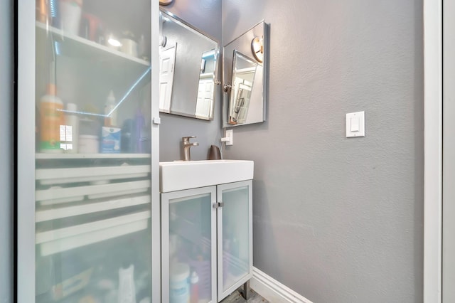 bathroom with vanity and a textured wall