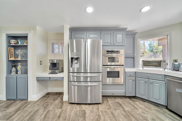 kitchen featuring stainless steel appliances, recessed lighting, light countertops, and gray cabinetry