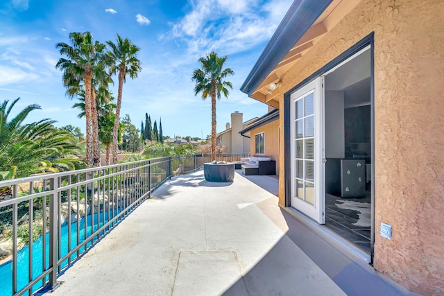 view of patio / terrace with an outdoor living space, a balcony, and a fenced in pool