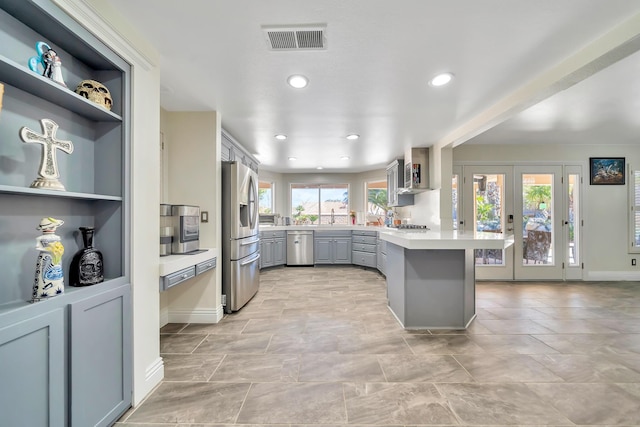 kitchen with stainless steel appliances, gray cabinets, light countertops, visible vents, and a peninsula