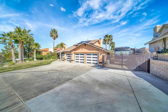 view of property exterior with stucco siding, an attached garage, a gate, fence, and driveway